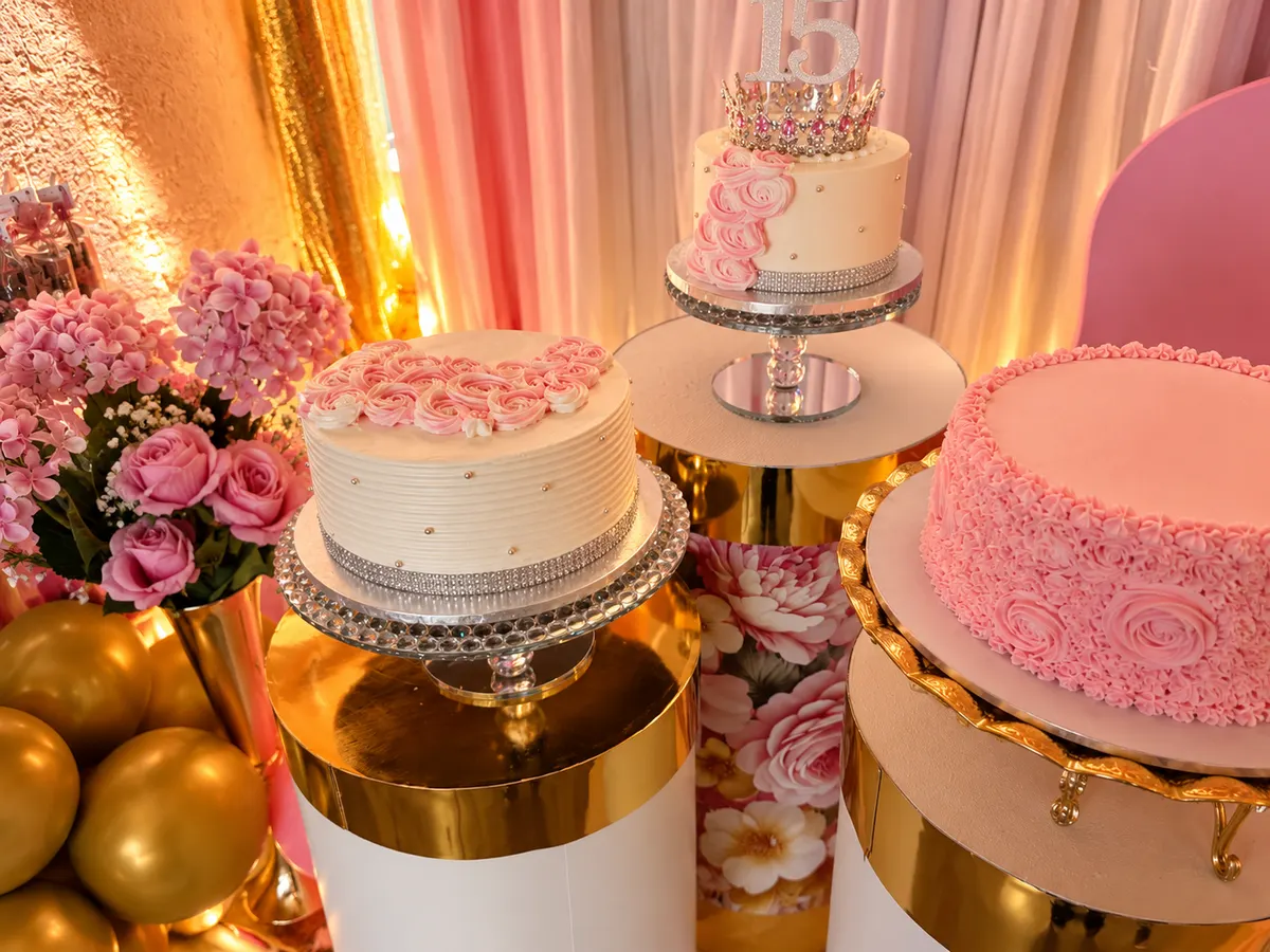 Tartas de XV años con corona y rosas de crema sobre bases doradas