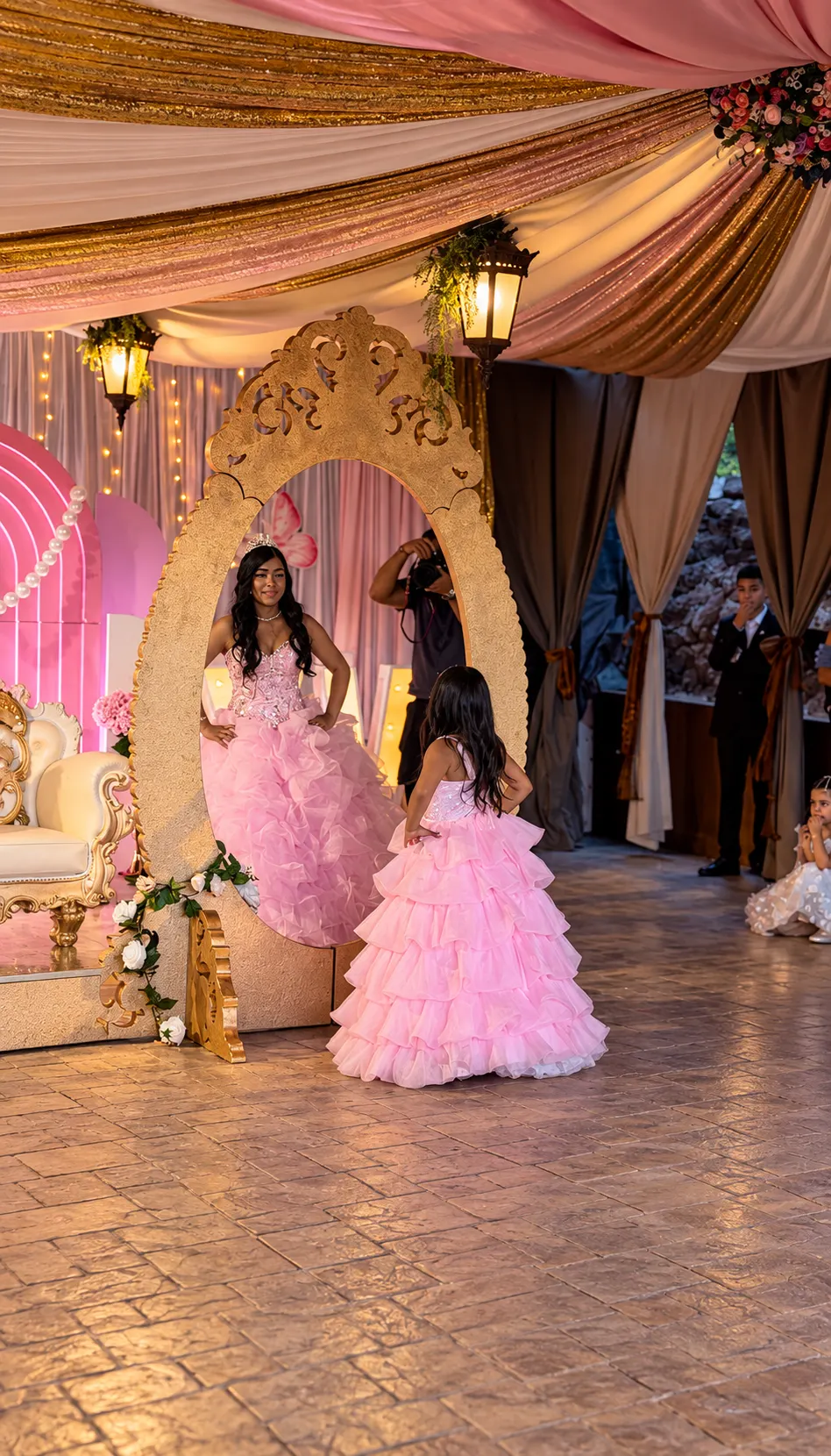 La quinceañera con vestido rosa ante el espejo dorado